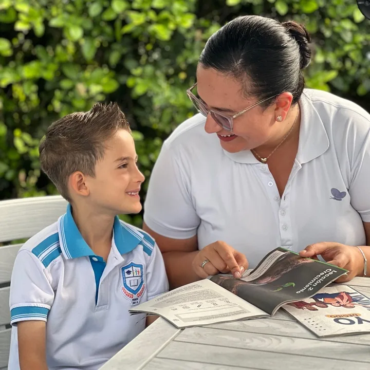 Maestra acompañando a un niño de primaria en la lectura